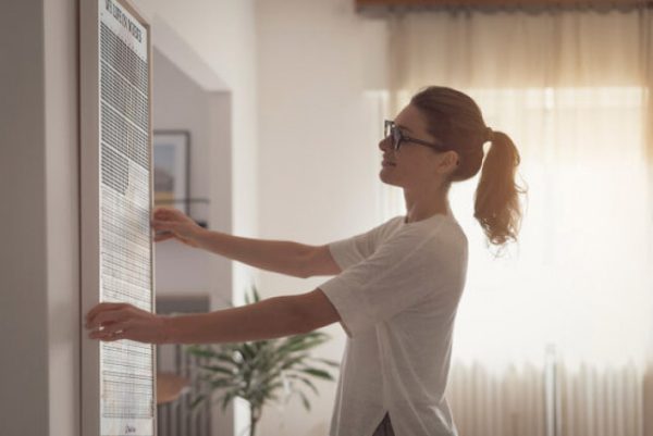 Woman hanging a 4k weeks poster at home